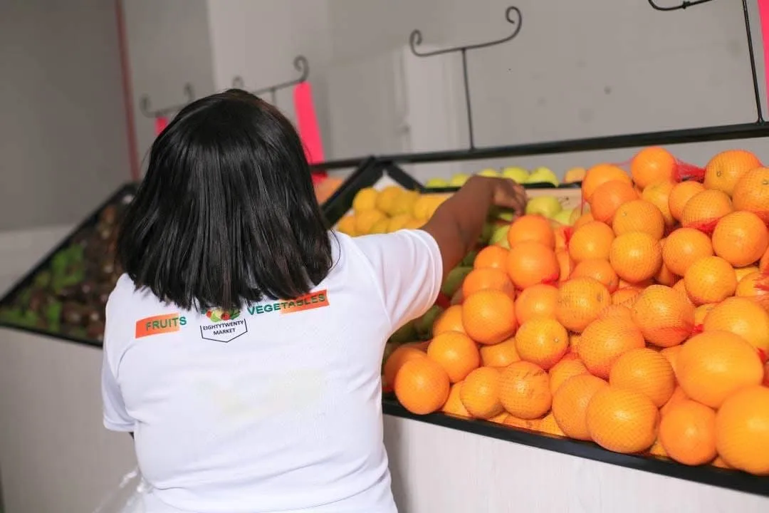 8020 Market staff stocking fresh oranges